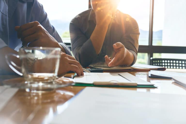 Business colleagues meeting to determine their duties to summarize annual performance in the company's meeting room. The documents, business contracts placed on a wooden table.